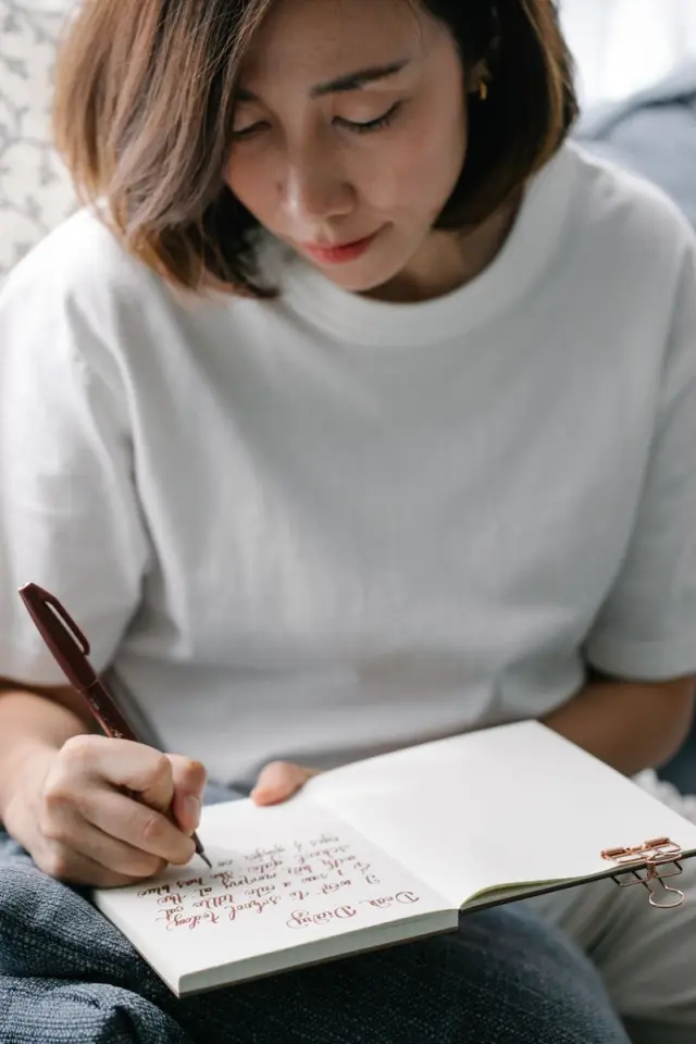 Una mujer escribiendo tranquila en un diario
